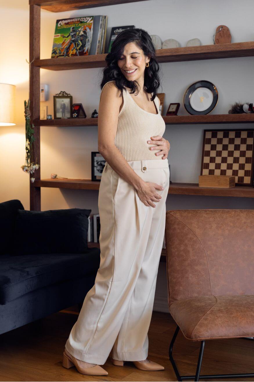 Femme enceinte qui sourit et porte une camisole d'allaitement