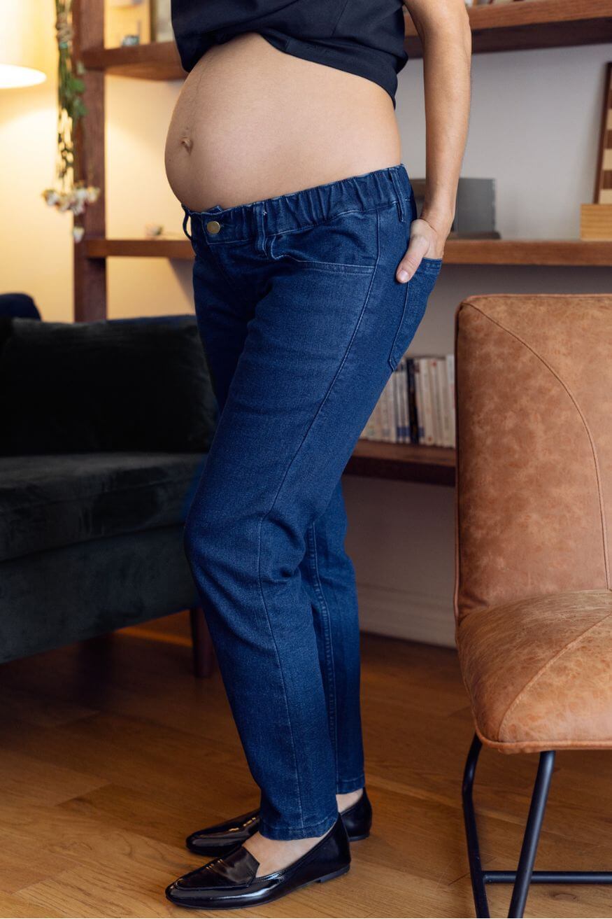 Jambes dans un jean de maternité bleu à taille elastique